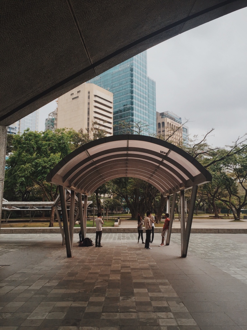 Photo of a group of teenagers under a sunshade in Ayala Triangle, Makati City
