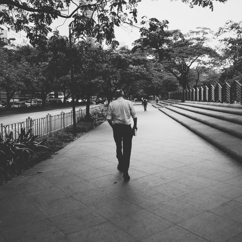 Photo of a man from behind, walking down Paseo De Roxas St. in Makati City